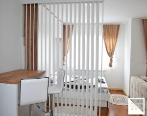 a white crib in a room with a bed at River Apartman in Bijelo Polje
