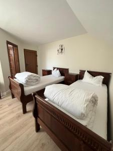 two twin beds in a room with wooden floors at ROUTE79 in Nojorid