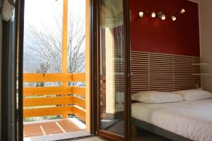 a bedroom with a bed and a sliding glass door at Agriturismo Deviscio in Lecco