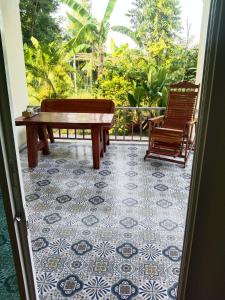 un portico con 2 panche e un tavolo su un pavimento piastrellato di Apartment a Prachuap Khiri Khan
