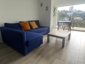 a living room with a blue couch and a table at Canyelles BBQ Apartment in Lloret de Mar