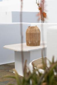 a small white table with a plant on it at Elena Hotel Mykonos in Mikonos