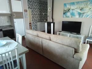 ein Wohnzimmer mit einem Sofa und einem TV in der Unterkunft Appartamento Loretta in Marciana Marina