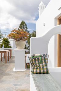 a white house with a bench and a vase at Elena Hotel Mykonos in Mýkonos City