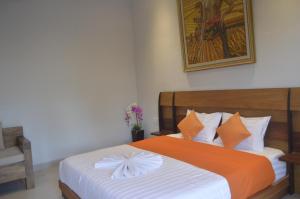 - une chambre avec un lit doté d'une couette orange et blanche dans l'établissement Banyu Riris Villa Lovina Private Villa, à Banjar