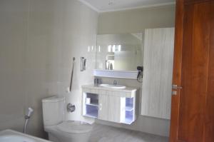 a bathroom with a toilet and a sink and a mirror at Banyu Riris Villa Lovina Private Villa in Banjar