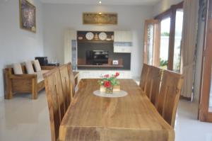 a dining room with a wooden table and chairs at Banyu Riris Villa Lovina Private Villa in Banjar