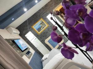 un jarrón con flores púrpuras en la sala de estar en PRESTIGE casa vacanze en Catanzaro