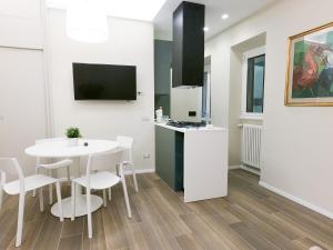 a kitchen and dining room with a white table and chairs at Holiday Ginevra-Campo de' Fiori in Rome
