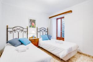 two beds in a room with a window at Cas Sastre 8 in Alcudia