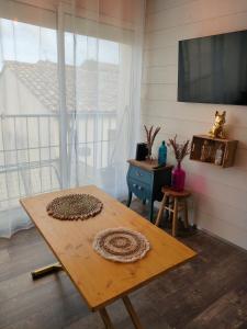 um quarto com uma mesa de madeira e uma televisão em La Cabane de Thau Location Cure ou Vacances à Balaruc les Bains em Balaruc-les-Bains