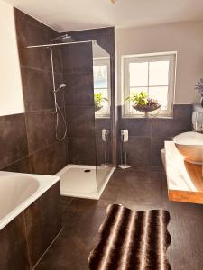 een badkamer met een douche, een bad en een wastafel bij Villenartiges Haus nahe See in Grebin