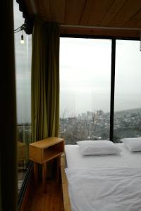 two beds in a room with a large window at Limoncello in Batumi