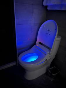 a toilet with a blue light in a bathroom at Five Rabbits in Chaozhou