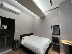 a bedroom with a white bed and a sink at Five Rabbits in Chaozhou