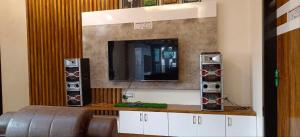 a room with a tv on a wall at Kantesha Nest in Shimoga