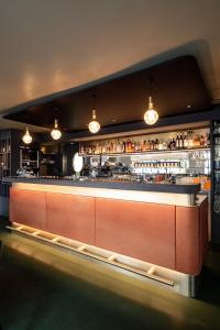 a bar in a restaurant with lights above it at Linde Heiden Swiss Quality Hotel in Heiden