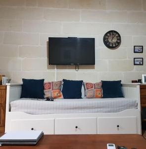 una camera con un letto e un orologio a muro di Traditional Maltese House in Birgu 