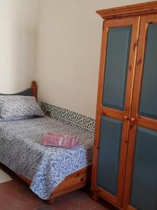 una camera con letto e armadio in legno di Traditional Maltese House in Birgu 