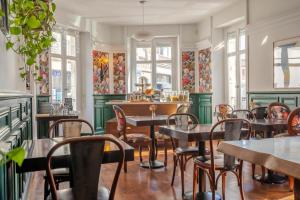 a restaurant with tables and chairs and windows at Ama Hôtel in Biarritz