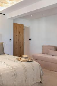 ein Schlafzimmer mit einem Bett mit Hut darauf in der Unterkunft Elena Hotel Mykonos in Mykonos Stadt