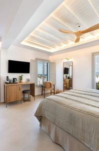 Schlafzimmer mit einem Bett und einem Flachbild-TV in der Unterkunft Elena Hotel Mykonos in Mykonos Stadt