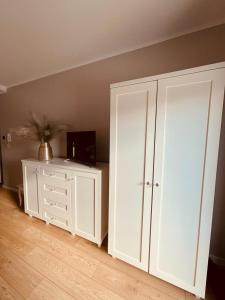 a room with a white cabinet and a tv at Apartament na Okrzei in Sandomierz