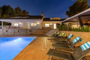 une villa avec une piscine et des chaises longues dans l'établissement Fidalsa Paradise Pines, à La Alcayna