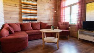 ein Wohnzimmer mit einem Sofa und einem Tisch in der Unterkunft Saija Lodge in Jokijärvi