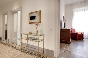 a living room with a table and a mirror at Mamo Florence - Magenta Apartment in Florence