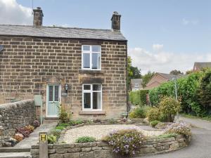 a brick house with a stone wall at Ryecroft in Matlock