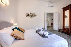 a bedroom with a large white bed with pillows at Mamo Florence - Magenta Apartment in Florence