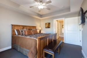 a bedroom with a wooden bed and a ceiling fan at W304-Mojave Skies Poolside 4 Bed Estancia Resort in St. George
