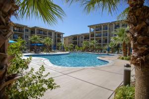 a pool at the resort with palm trees and buildings at W304-Mojave Skies Poolside 4 Bed Estancia Resort in St. George