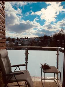 una silla y una mesa en un balcón con vistas en Apartament na Okrzei, en Sandomierz