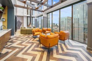 ein Wohnzimmer mit orangefarbenen Möbeln und großen Fenstern in der Unterkunft First Hill 1BR w Gym Coworking SEA-437 in Seattle