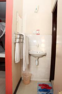 Darajani Hotel في مومباسا: حمام مع حوض ومرآة