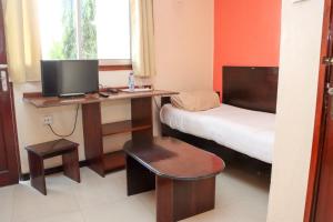 a room with a desk with a bed and a computer at Darajani Hotel in Mombasa