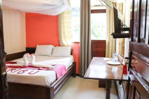 Deux cygnes sont assis sur un lit dans une pièce dans l'établissement Darajani Hotel, à Mombasa