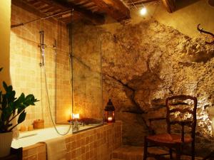 een badkamer met een douche, een stoel en een bad bij La Vita Dolce, Luberon in Grambois