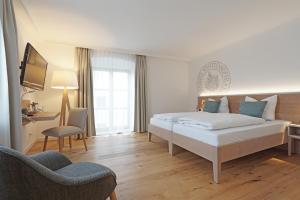 um quarto com uma cama, uma secretária e uma cadeira em Schattenhofer Braugasthof em Beilngries