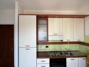 una cucina con armadi bianchi e lavandino di Apartment Milan - Città Studi a Milano