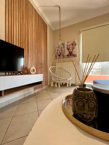 a living room with a tv and a table at Karma - Modern Apartment in Kanálion