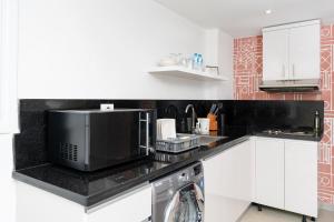 a kitchen with a microwave and a dishwasher at Brassbell apartments by the Pyramids in Cairo