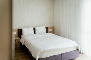 ein Schlafzimmer mit einem großen Bett mit weißer Bettwäsche in der Unterkunft Lamede in Wiener Neustadt
