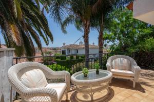 a patio with two chairs and a table with a potted plant at Stunning Villa with private pool Ref 30 in Santa Fe de los Boliches