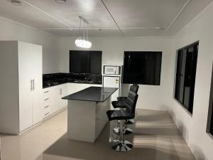 a kitchen with white cabinets and a black counter top at Bula Homestay in Labasa