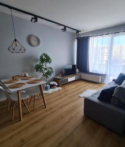 a living room with a table and a couch at Posnania Comfort Apartment, free parking, self check-in 24h in Poznań