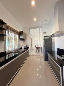 a kitchen with black and white counters and a refrigerator at Private house Casa seaside Rayong in Ban Chak Phai