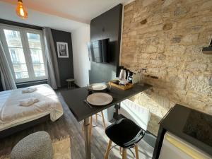 um pequeno quarto com uma mesa e uma cama e um quarto em Timus YourHostHelper em Caen